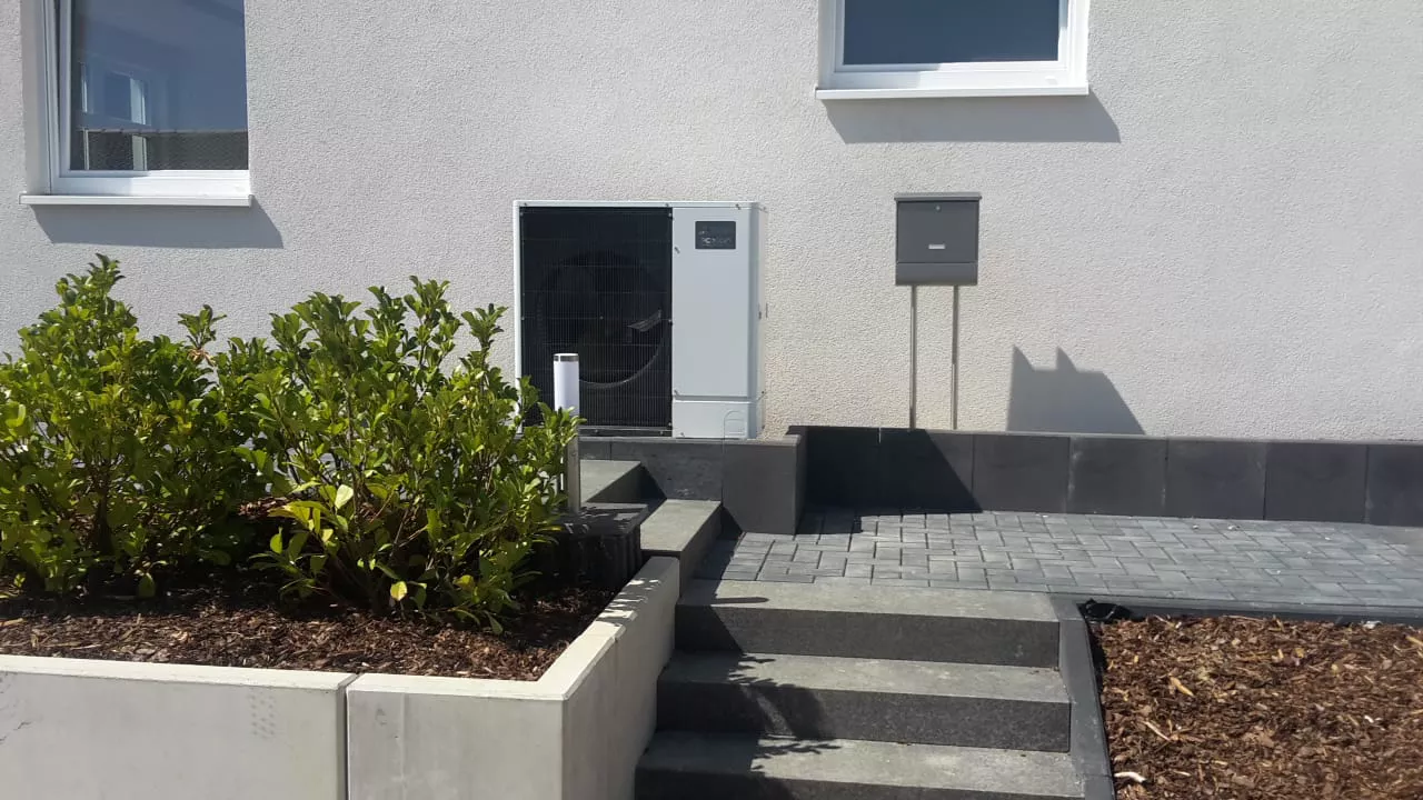 Wärmepumpen-Außengerät neben dem Hauseingang